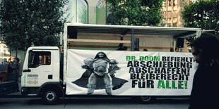 Dr. Doom auf einem Demo-Banner gegen Abschiebungen an einer LKW-Plane