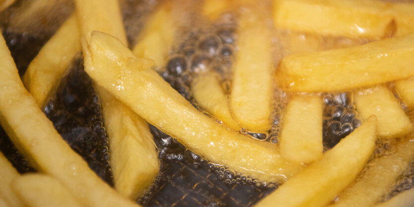 Pommes liegen in brutzelndem Fett