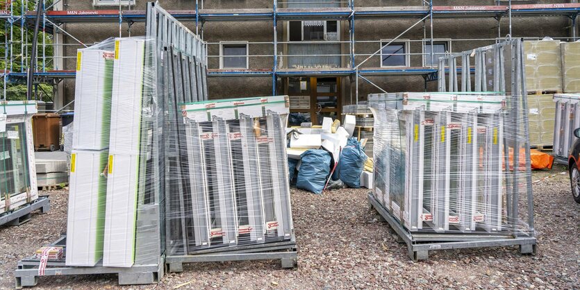 Materialien für neue Fenster und neue Dachdeckung vor einem Gebäude