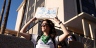 Eine Frau hält ein Plakat mit der Aufschrift "Your hate only blocks safe abortions"