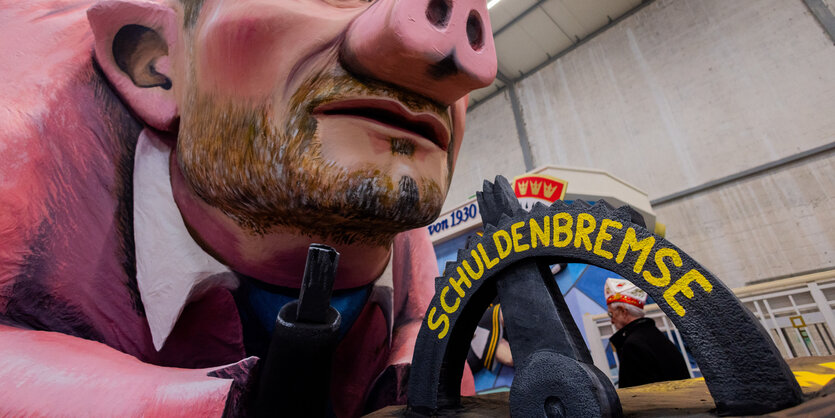 Das Bild zeigt einen Wagen des Kölner Rosenmontagszugs mit der Aufschrift "Schuldenbremse".