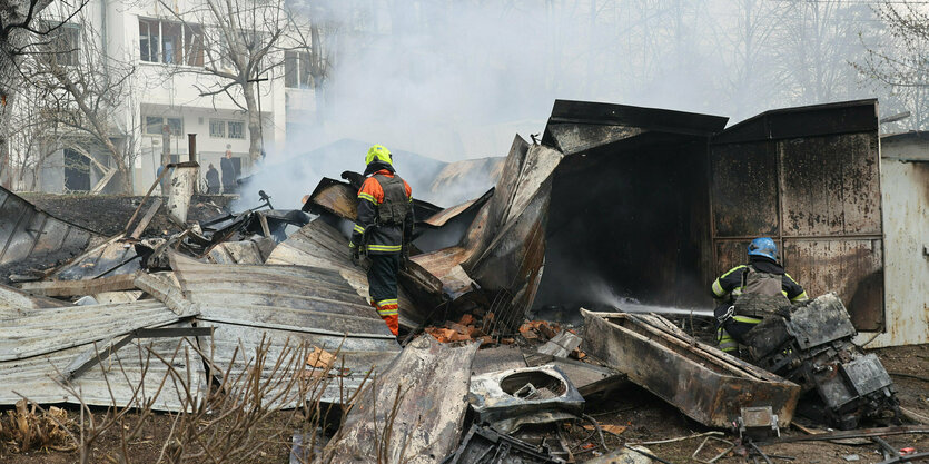 Feuerwehrleute löschen ein Feuer nachdem eine russische Präzisionsmunition zivile Infrastrukturen in charkiw im Nordosten der Ukraine getroffen hat.