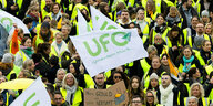 Streikende Flugbegleiter ziehen mit Bannern und Ufo-Fahnen zum Lufthansa Aviation Center