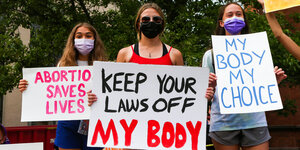 Frauen, die für das Recht auf Abtreibung demonstrieren, halten Plakate während einer Kundgebung vor dem Gerichtsgebäude von Columbia County