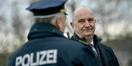 Ministerpräsident Woidke grinst einen Polizisten an