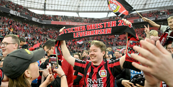 Bayer-Fans jubeln auf dem Spielfeld.