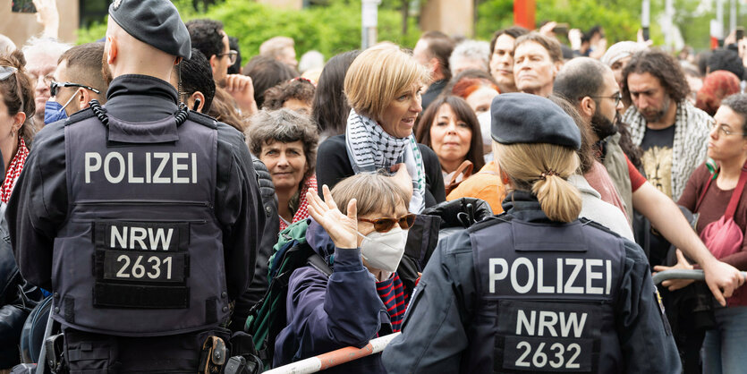 Menschenmenge steht vor PolizistInnen