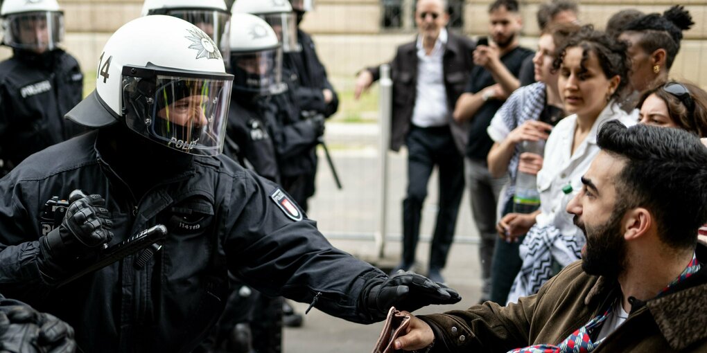 Ein Polizist und ein Demonstrant stoßen auf einer Demonstration nach der Auflösung der «Palästina Konferenz» in Berlin-Mitte zusammen. Der Polizist in Riotgear ballt seine Faust und droht zum Schlag auszuholen. Die Berliner Polizei hat den umstrittenen kongress, der eigentlich bis Sonntag dauern sollte, am Freitag aufgelöst.