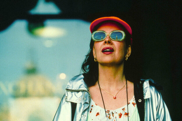 Actress Licia Maglietta wears a red cap and sunglasses and looks up