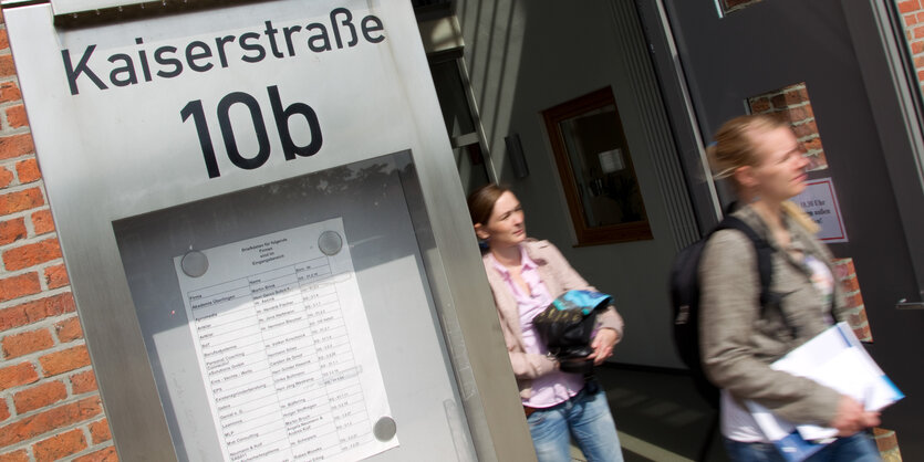 Zwei junge Frauen verlassen ein Universitätsgebäude