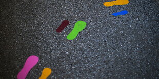 Bunte Fußspuren auf dem Asphalt