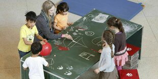 Kinder malen an einem Tisch beim tazlab 2015