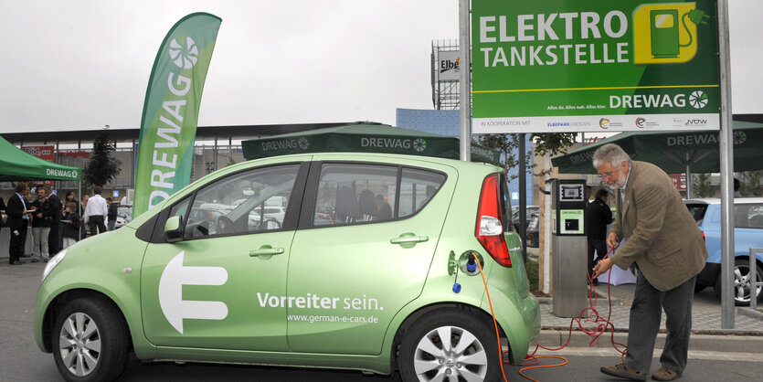 Ein Mann lädt sein Elektroauto