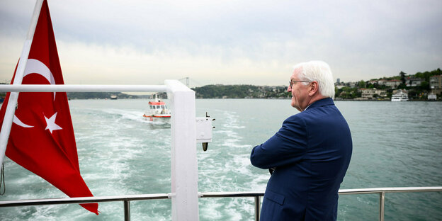 Bundespräsident Steinmeier steht auf einem Schiff an der Reeling und schaut über den Bosporus, links neben ihm flattert eine türkische Flagge