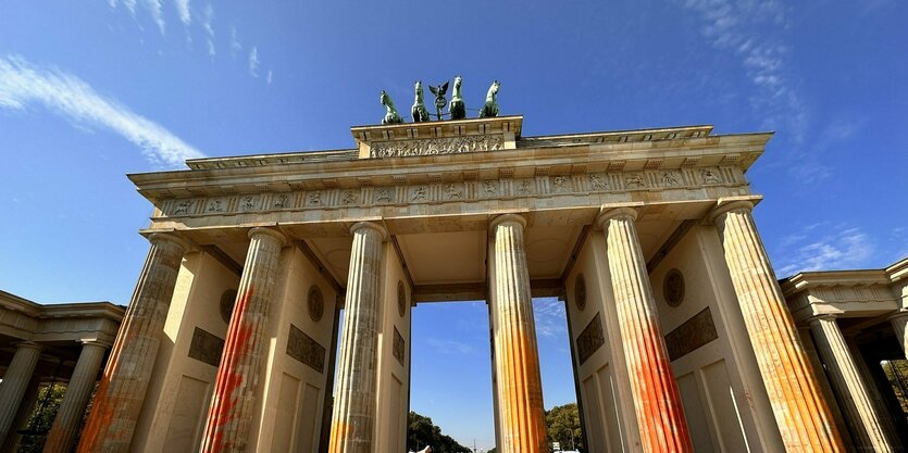 Man sieht das Brandeburger Tor mit orangenen Flecken.