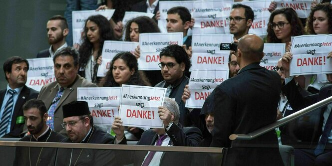 Besucher halten im Bundestag auf der Besuchertribüne Zettel mit der Aufschrift „AnerkennungJetzt sagt Danke“