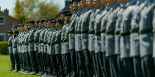 Rekruten stehen stramm zusammen in Uniform bei einem feierlichen Gelöbnis