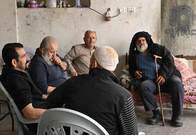 Eine Gruppe alter Männer sitzt beieinander