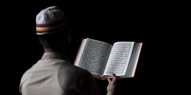 Ein Mensch liest den Koran