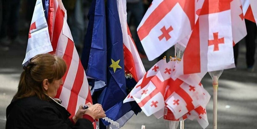 Eine Protestierende mit georgischen und europäischen Flaggen.