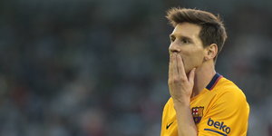 Lionel Messi hält sich eine Hand vor den Mund