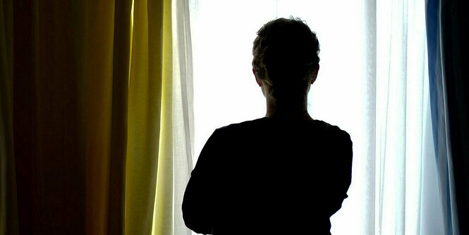 Silhouette einer Frau, die an einem Fenster steht