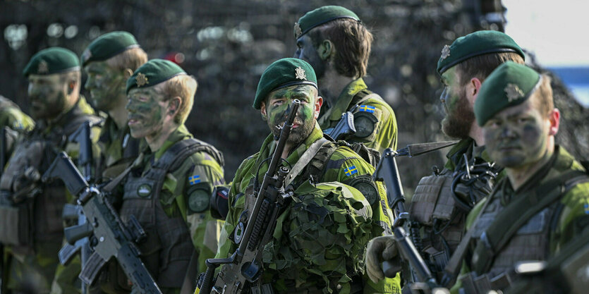 Soldaten stehen mit ihren Gewehren auf einem Militärstützpunkt