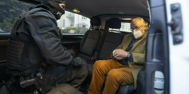 Prinz Reuss sitzt gefesselt in einem Polizeifahrzeug