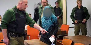 Polizisten und eine Angeklagte im Münchner Landgericht