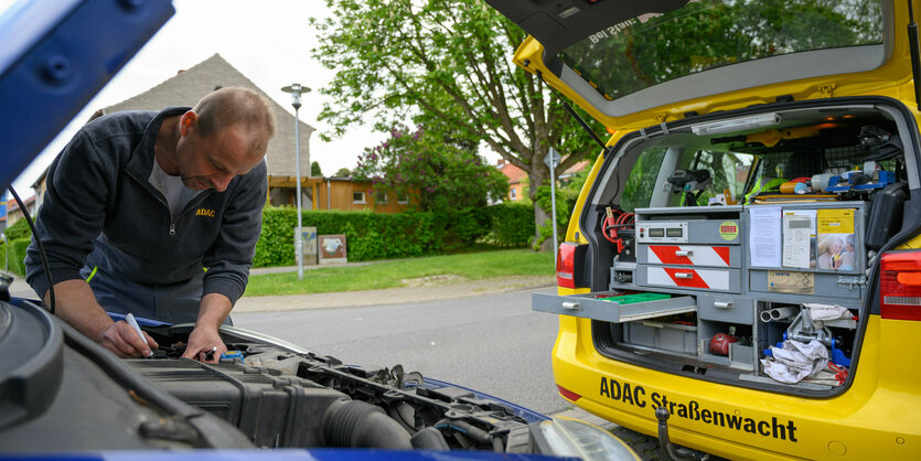 Monteur vom ADAC beugt sich über Motor