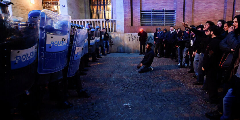 Links eine Polizeikette, rechts wütenden Demonstrant:innen