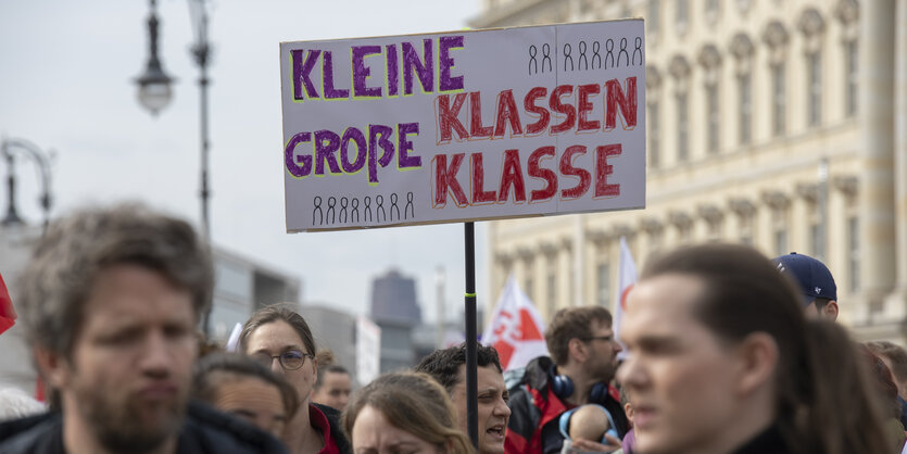 Bild von einer Demo. Im Zentrum ist ein Protestschild: Keine Klassen Große Klasse