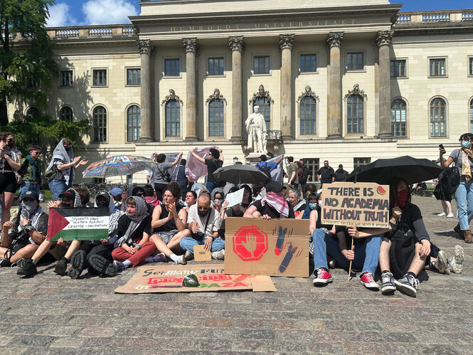 Zu sehen ist eine Gruppe Demonstrierender vor der Humboldt-Univeristät