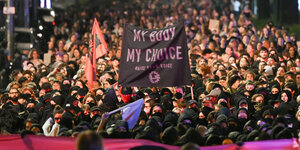 Demonstration mit schwarz vermummten Personen am Anfang. Sie halten ein Banner mit der Aufschrift "My body my choice"