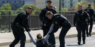 Ein Klimaaktivist wird in Dresden von der Polizei von der Straße getragen