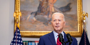 US-Präsident Joe Biden steht vor einem Bild und spricht