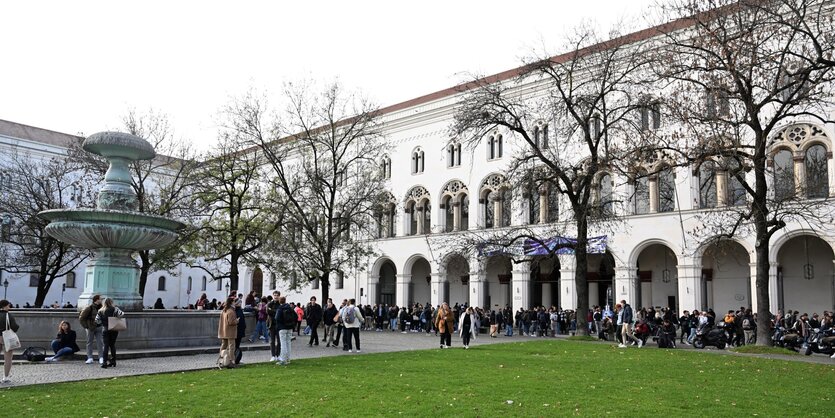 Studenten stehen vor dem Hauptgebäude der LMU