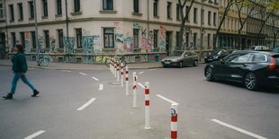 rot-weiße Poller auf einer Straßenkreuzung verhindern freie Durchfahrt für Autos