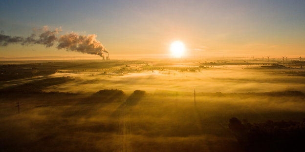 Strahlende Morgensonne, am Horizont ein Kohlekraftwerk