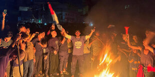feiernde Menschen um ein Feuer herum