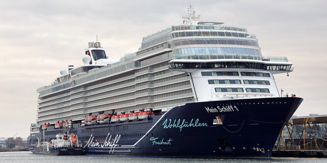 Ein Kreuzfahrtschiff mit der Aufschrift Wohlfühlen, Freiheit und Mein Schiff hat an einem Anleger festgemacht