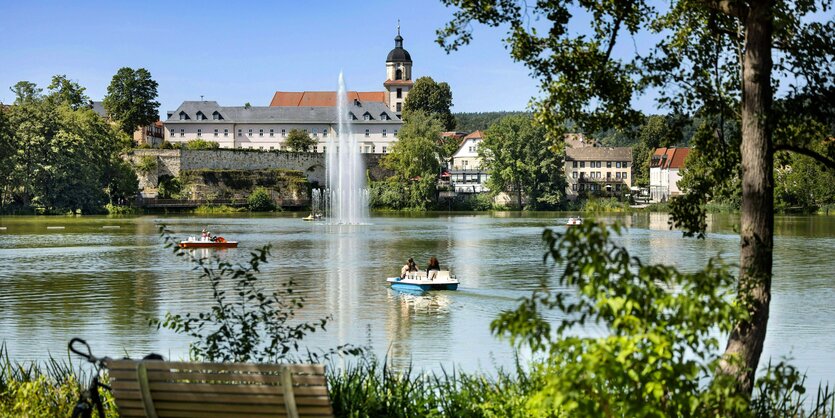 Menschen fahren Tretboot auf dem Burgsee