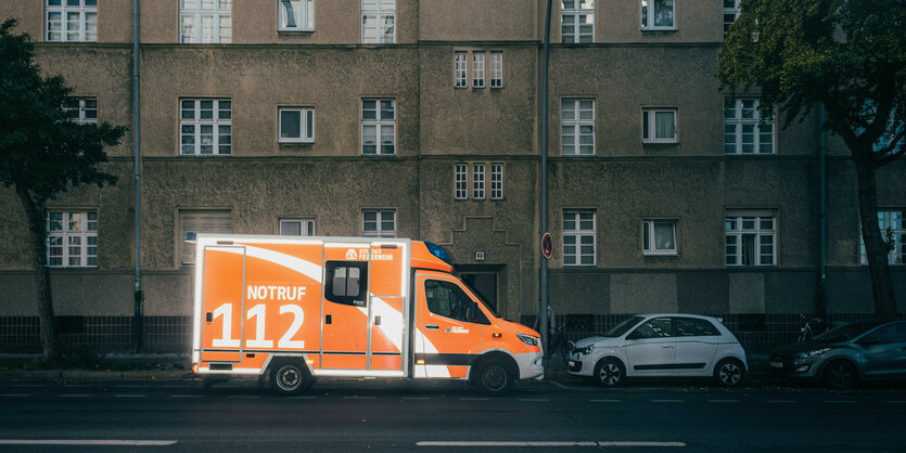 Ein Krankenwagen steht vor einer tristen Häuserzeile.