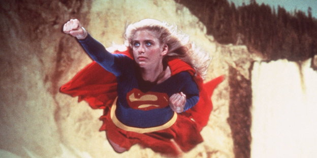 Eine Frau fliegt im Superheldinnenkostum