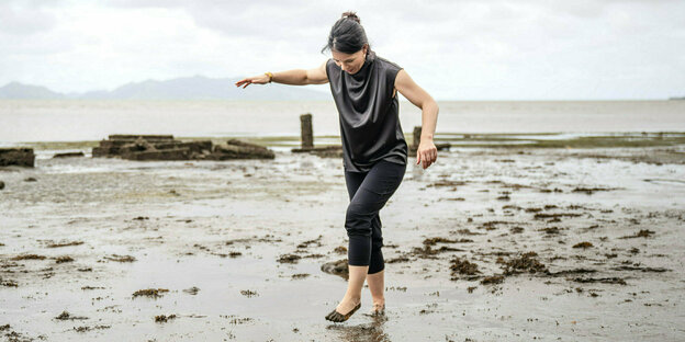 Annalena Baerbock läuft ohne Schuhe über einen schlammigen Strand