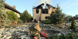 Retttungskraft vor zerstörtem Haus