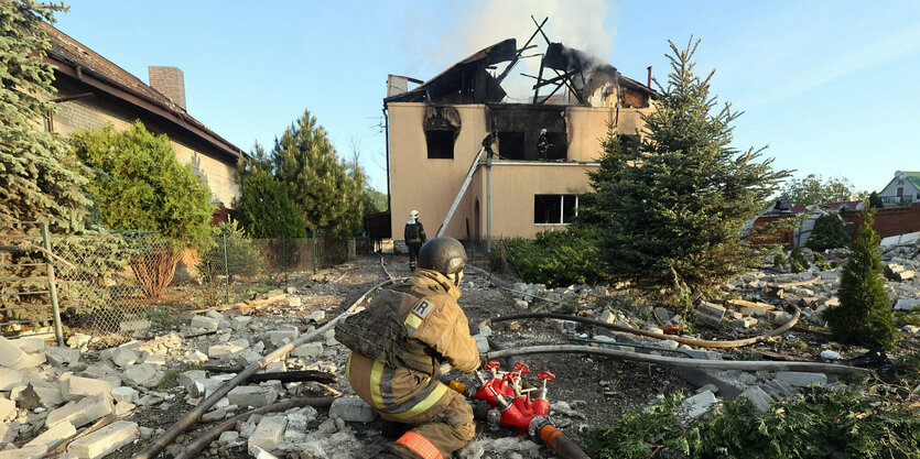 Retttungskraft vor zerstörtem Haus