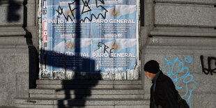 Ein Mann geht an Plakaten mit der Aufschrift: "Generalstreik" vorbei