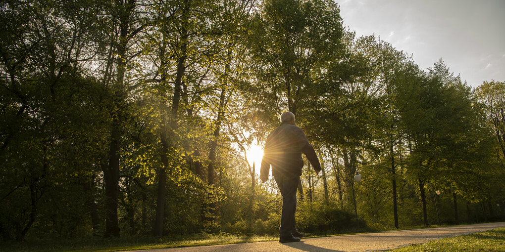 Ein Mann geht im Tiergarten in Berlin spazieren