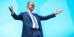 Friedrich Merz streckt freudig die Arme aus